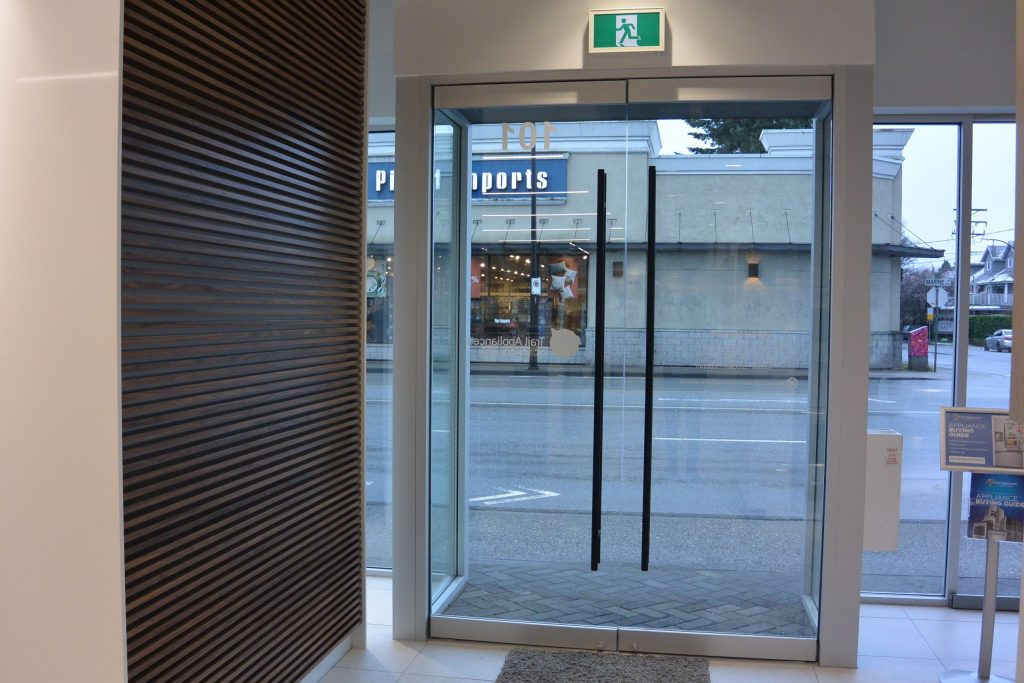 Frameless glass storefront entrance installed by Niki Design and Glass Studio in North Vancouver